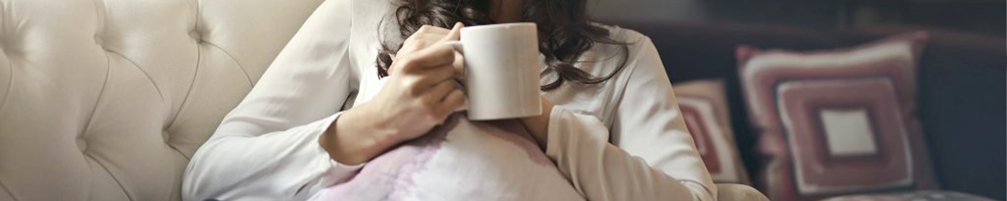 woman sitting on couch holding mug